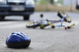 Bicycle and helmet lying on the road after a collision with a vehicle