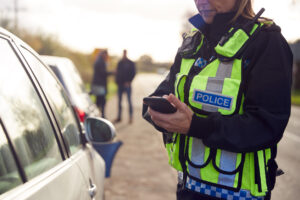 Police officer taking a report at the scene of a roadside collision